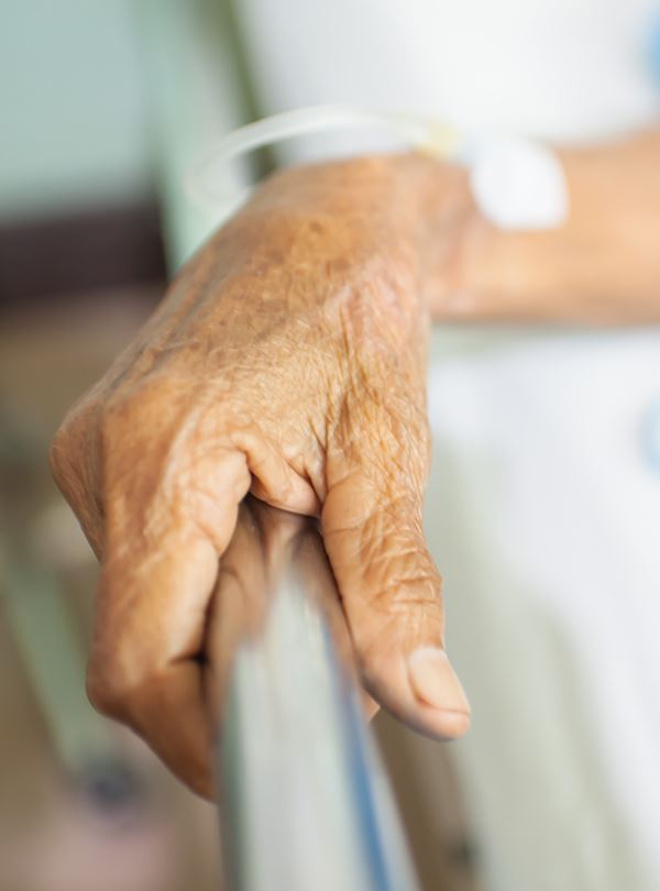 Elderly Hand Holding on to a Hospital Bed 