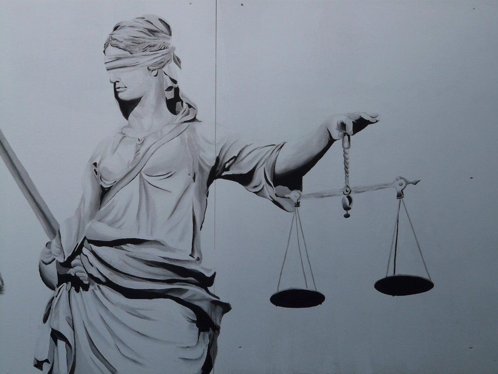 Lady Justice statue holding a set of scales, symbolizing fair legal representation