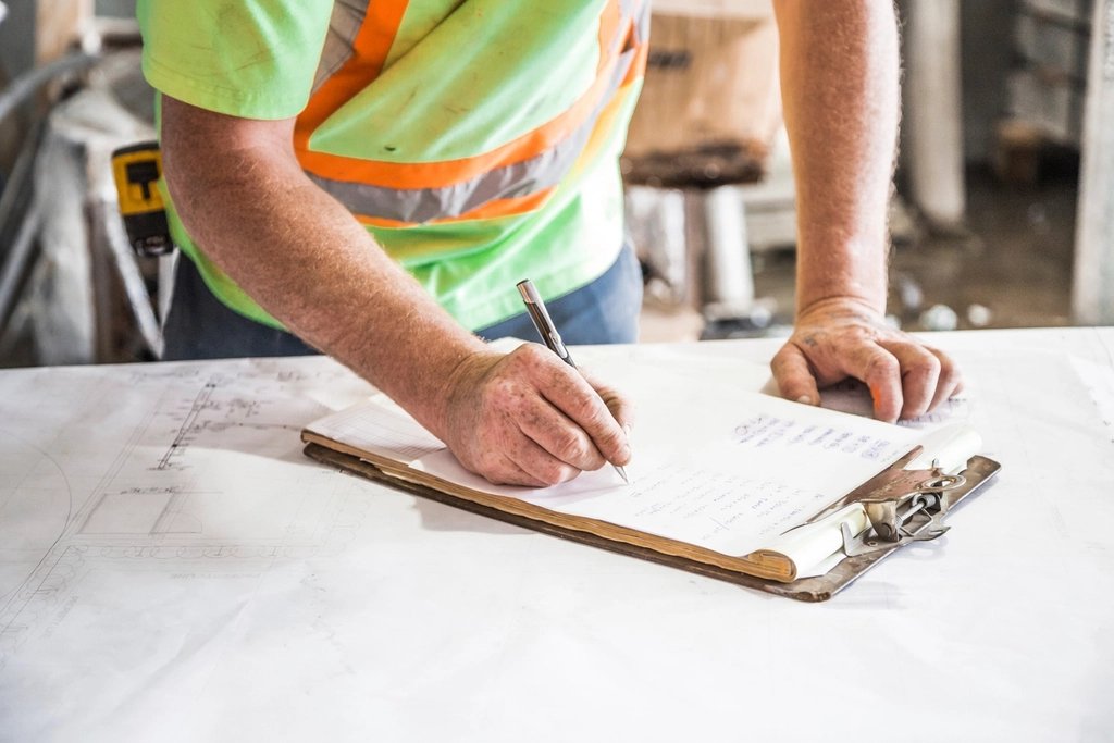 A worker reviewing paperwork on a clipboard